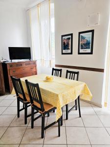 a dining room table with chairs and a yellow checkered table cloth at Narissara apartment in La Spezia