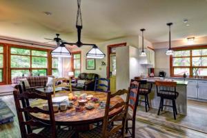 a kitchen and living room with a table and chairs at Tremblant Les Eaux D - Mont-Tremblant in Mont-Tremblant