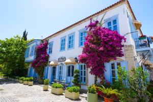 a white building with purple flowers on it at Alaçatı Taş Otel in Alaçatı