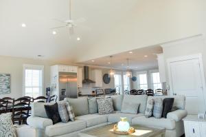 a living room with a couch and a kitchen at Family Tides North Topsail Beach in North Topsail Beach