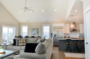 a living room with two couches and a kitchen at Family Tides North Topsail Beach in North Topsail Beach