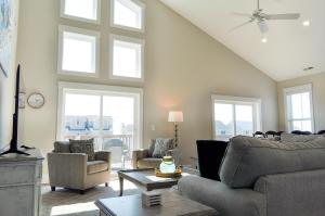 a living room with a couch and chairs and windows at Family Tides North Topsail Beach in North Topsail Beach