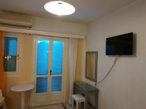 Habitación con TV, mesa y ventana. en Renia Studios, en Agia Pelagia