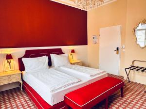 Schlafzimmer mit einem Bett mit einem roten Kopfteil und einer roten Bank in der Unterkunft Aviano Boutiquehotel in Wien