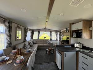 a living room with a couch and a table in a caravan at Visma Caravan in Llanddwywe