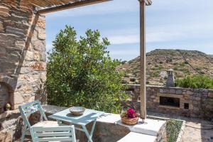 a patio with a table and a stone fireplace at Villa Margarita Studio in Patmos