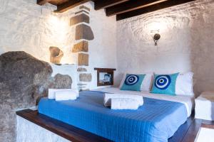 um quarto com uma cama com almofadas azuis e brancas em Villa Margarita Studio em Patmos