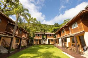 a courtyard of a house with a grass yard at Pousada Villa Encantada Ilha do Mel in Ilha do Mel