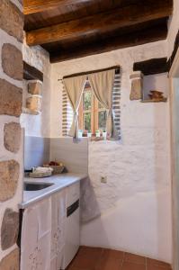 uma cozinha com um lavatório e uma janela em Villa Margarita Studio em Patmos