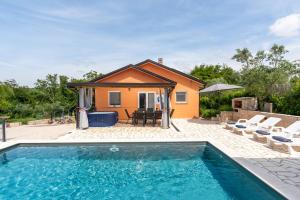 a house with a swimming pool in front of a house at Villa Pendolina with Private Pool in Buje