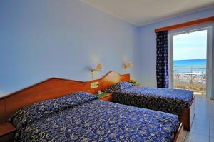 a bedroom with two beds and a view of the ocean at Astir Palace Hotel in Laganas