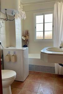 a bathroom with a toilet and a tub and a sink at Buena Vista in Alhaurín de la Torre