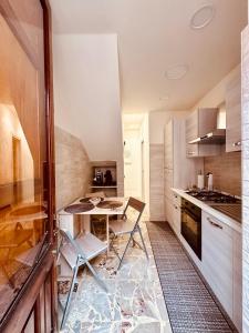 a kitchen with a table and chairs in a room at Sotto l'Arco in Acireale