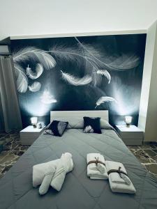 a bedroom with a large bed with white towels at Sotto l'Arco in Acireale
