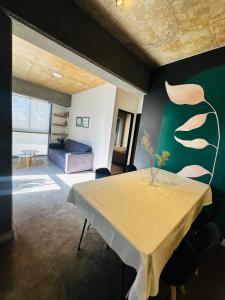 a living room with a table and a green wall at El olivo departamentos in San Salvador de Jujuy