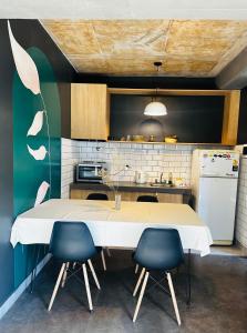 a kitchen with a white table and two blue chairs at El olivo departamentos in San Salvador de Jujuy