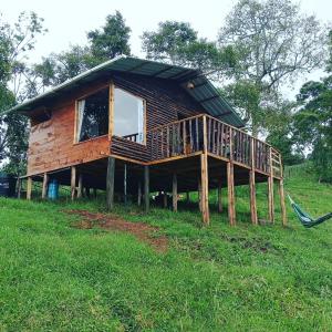 a log house with a porch and a swing at Cabaña Bella Vista - Arbeláez in Arbeláez
