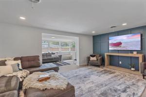 un salon avec un canapé et une télévision à écran plat dans l'établissement The Wisteria Oasis With heated pool and hot tub, à Sarasota