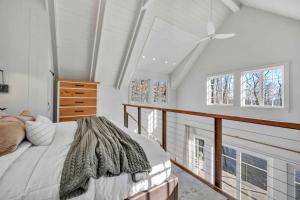 a bedroom with white walls and a bed and windows at The Roundtop Chalet romantic couples getaway in Wrightsville
