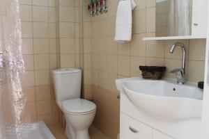 a bathroom with a white toilet and a sink at Apartment Lucia in Argostoli +21 photos