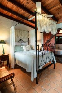 una camera da letto con un letto a baldacchino in una stanza di Blue Fattoria Luxury Farm Accomodation a Fernside