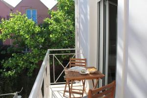 a table and chair on the balcony of a building at Apartment Lucia in Argostoli
