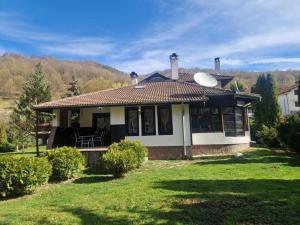 a small house with a grassy yard at Къща за гости Бели Вит in Ribarica