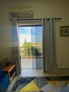 een woonkamer met een glazen schuifdeur naar een balkon bij Departamento al lado de Fortis in Ciudad del Este