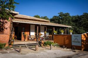 ein Backsteinhaus mit einer Veranda mit Pflanzen darauf in der Unterkunft Pousada Rancho Soberbo, Serra do Cipó in Santana do Riacho