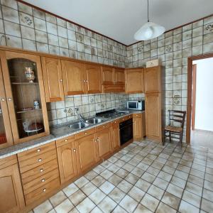 a kitchen with wooden cabinets and a sink at Casa vacanze Milena in Milena