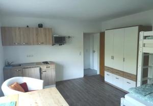 een keuken met witte kasten en een tafel in een kamer bij Struthhof Ferienwohnung in Finsternthal