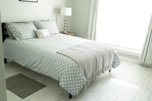 a bed in a white bedroom with a window at Walking distance to Coler MTN Bike - 3BR 2BA in Bentonville