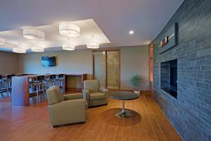a lobby with chairs and a fireplace and a bar at Holiday Inn Express Hotel & Suites Saint - Hyacinthe, an IHG Hotel in Saint-Hyacinthe