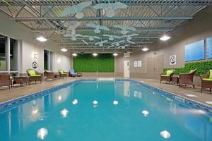 a pool in a hotel with chairs and tables at Holiday Inn Express Hotel & Suites Saint - Hyacinthe, an IHG Hotel in Saint-Hyacinthe