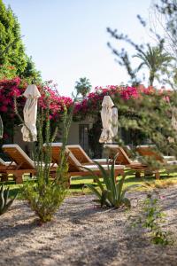 un grupo de mesas y sillas en un patio con flores en Casa Cody, en Palm Springs