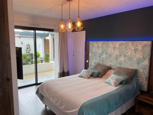a bedroom with a large bed with two pillows at Mini Villa d'Exception avec Piscine Jacuzzi Sauna et Home Cinema Privés in La Baule