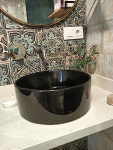 lavabo negro en el baño con espejo en LA RESERVA EL JARDiN, en Tarifa