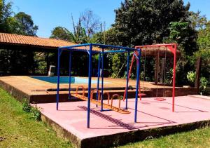 un parque infantil frente a una piscina en Pousada Rural Vargem do Cedro, en Belo Vale