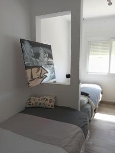 Un dormitorio con dos camas en una habitación con ventana. en LA RESERVA EL JARDiN, en Tarifa