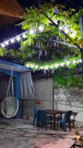 a patio with a table and chairs and purple flowers at Makos Guest House in Kutaisi