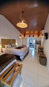 um quarto amplo com 2 camas e um lustre em Vila Capininga Ecopousada em Santo Amaro
