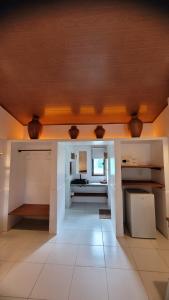 uma cozinha com paredes brancas e um tecto de madeira em Vila Capininga Ecopousada em Santo Amaro