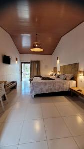 um quarto grande com uma cama grande e um lustre em Vila Capininga Ecopousada em Santo Amaro