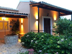 a house with a porch and some bushes and flowers at Casa Ortensia in Kato Korakiana