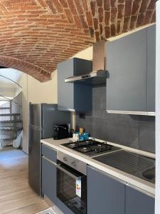 a kitchen with a stove and a refrigerator at Maison Du Bois in Rivarolo Canavese
