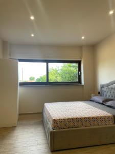 a bedroom with a bed and a large window at Maison Du Bois in Rivarolo Canavese