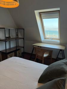 a bedroom with a bed and a desk and a window at Casa das Sereas in Laxe