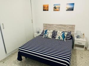 A bed or beds in a room at Apartamento Conil Playa & céntrico, con Aire Acond y WIFI -SOLO FAMILIAS Y PAREJAS-