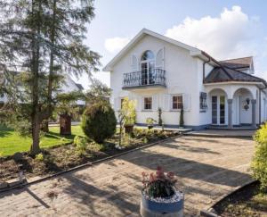 a large white house with a courtyard at Villa kleinwellness in Lanaken