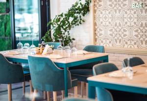 a dining room with tables and chairs with wine glasses at La Onda Hotel Durres in Durrës